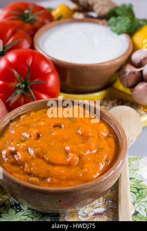 Schüssel mit pflanzlichen Tikka Masala Sauce und Zutaten, die eingehen, so dass es - rote Tomaten, Paprika, Karotten, Koriander Blätter, Zwiebel, Knoblauch, Juwel Stockfoto