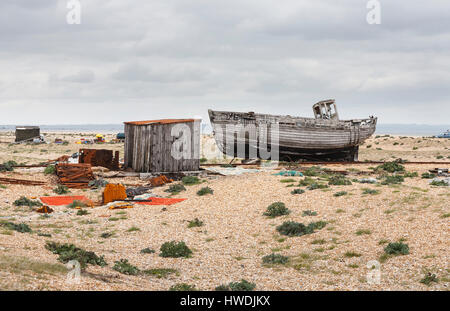 Aufgegeben, faulenden Hölzer Fischerboot und Ausrüstung an der trostlosen Kies Strand Küste bei Dungeness, Shepway Bezirk, Kent Stockfoto