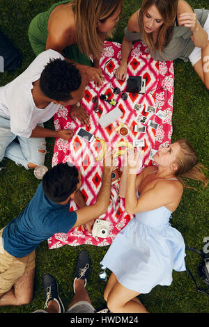 Draufsicht von fünf Erwachsenen Freunden Picknick im park Stockfoto