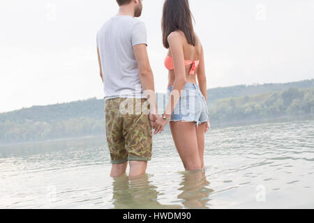 Paar Hand in Hand durch Fluss Stockfoto