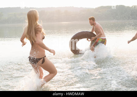 Freunde, die Spaß mit aufblasbaren Ring im Fluss Stockfoto