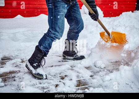 Mann, die Schaufeln Schnee vom Weg, niedrige Abschnitt Stockfoto