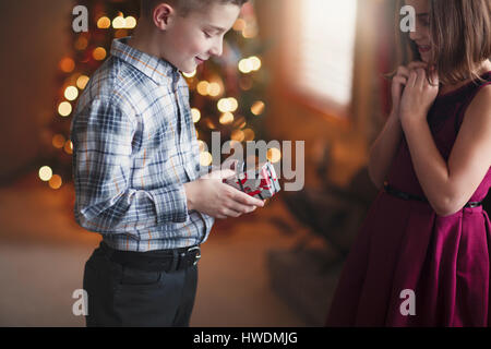 Bruder und Schwester ihre Weihnachtsgeschenke austauschen Stockfoto