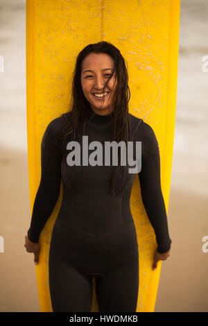 Porträt der jungen Frau, mit Surfbrett Stockfoto