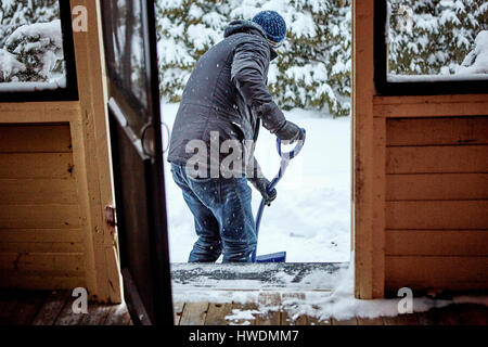 Mann, die Schaufeln Schnee vom Weg, Rückansicht Stockfoto