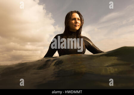 Junge Frau im Meer, sitzen auf Surfbrett, Paddeln Stockfoto