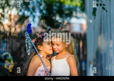 Zwei junge Mädchen gekleidet wie Feen, Mädchen, Freundin ins Ohr flüstern Stockfoto