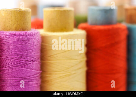 Rollen oder Spulen von bunten Nähfäden. Gewinde in allen Farben. Geringe Schärfentiefe. Nahaufnahme Makro erschossen. Stockfoto