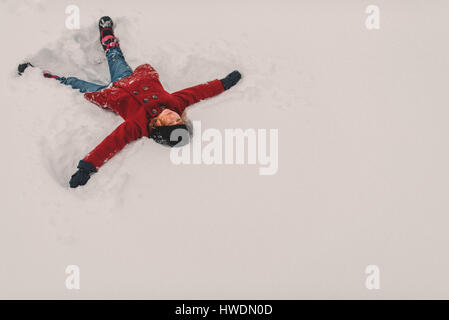 Mädchen auf Schnee liegen Stockfoto