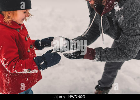 Vater und Tochter spielen im Schnee Stockfoto