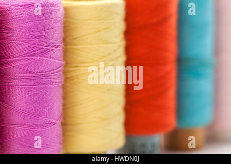 Rollen oder Spulen von bunten Nähfäden. Gewinde in allen Farben. Geringe Schärfentiefe. Nahaufnahme Makro erschossen. Stockfoto