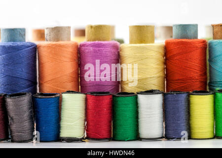 Rollen oder Spulen von bunten Nähfäden. Gewinde in allen Farben. Geringe Schärfentiefe. Nahaufnahme Makro erschossen. Stockfoto