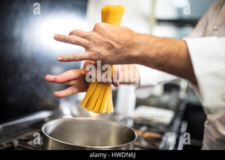 Koch, Spaghetti im Topf auf Herd, Nahaufnahme, obenliegende Ansicht Stockfoto