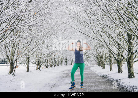 Porträt der Frau biegen Muskeln, im Schnee bedeckt Landschaft im ländlichen Raum Stockfoto