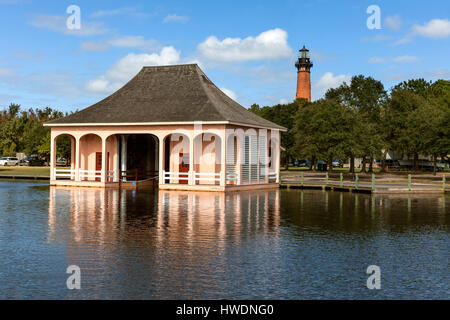 NC00692-00... NORTH CAROLINA - Bootshaus an der Whalehead-Club mit Currituck Beach Light Station in der Ferne. Stockfoto