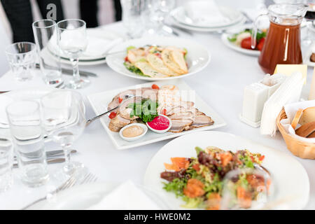 Tisch im Restaurant essen. Leckere Vorspeisen, Salate. Verschiedene Gerichte für die Gäste auf der Hochzeitstisch Stockfoto