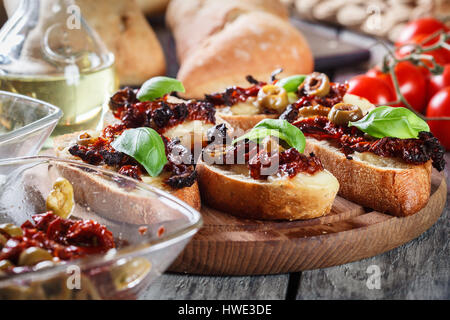 Vorspeise-Bruschetta mit getrockneten Tomaten, Oliven und Mozarella. Italienische Küche Stockfoto