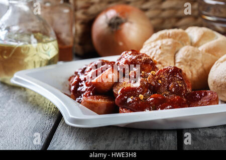 Köstliche deutsche Currywurst - Stücke Wurst mit Curry-Sauce und Brötchen Stockfoto