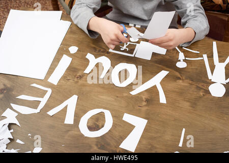 junge macht Origami - Auto und Familie, Kinder, Eltern, ich liebe dich Text, Draufsicht auf Holz Hintergrund Stockfoto
