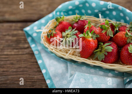 Frische Erdbeeren in Wicker Tablett auf Holztisch Stockfoto