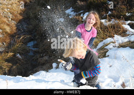 Kinder haben einen Schneeball kämpfen mit volle Wirkung Stockfoto