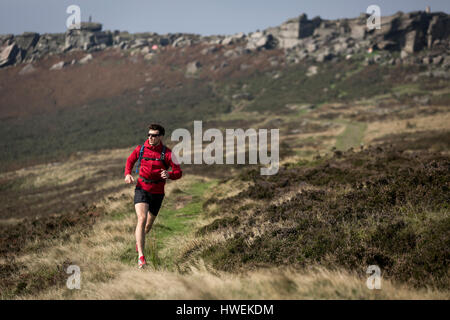 Männliche Läufer läuft in der Nähe von Stanage Edge, Peak District, Derbyshire, UK Stockfoto