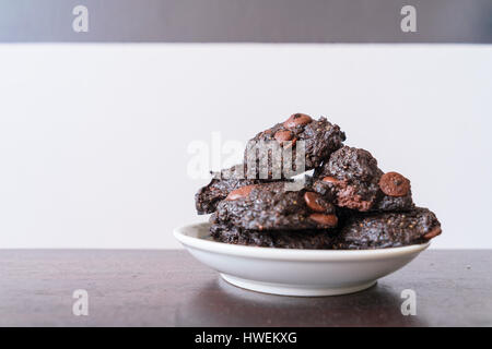 Stack vegane Schokolade Brownie Cookies auf weiße Runde Platte Stockfoto