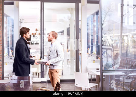 Zwei junge Geschäftsleute Händeschütteln im Büro Stockfoto