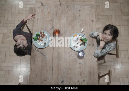 Obenliegende Porträt von Schwester und Bruder Essen am Küchentisch Stockfoto