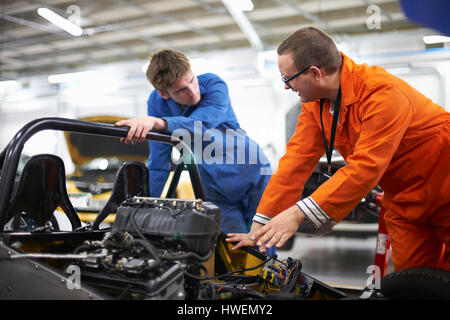 Mechaniker Studenten diskutieren Rennmotors Auto in Werkstatt Stockfoto