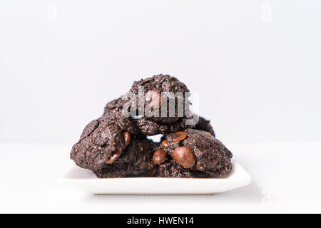 Stack vegane Schokolade Brownie Cookies auf weiße quadratische Platte Stockfoto