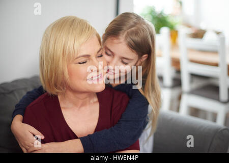 Enkelin umarmt Großmutter Stockfoto