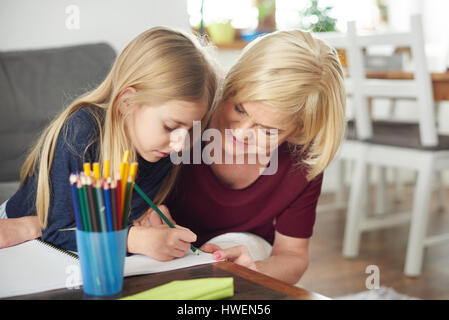 Großmutter Enkelin bei Hausaufgaben zu Hause helfen Stockfoto