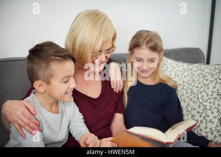 Großmutter und Enkel Buch auf sofa Stockfoto