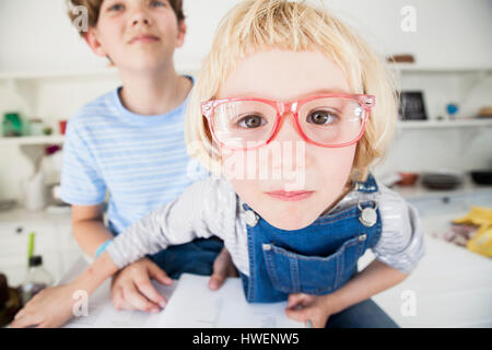Porträt von netten Mädchen in Brillen mit Bruder in Küche Stockfoto