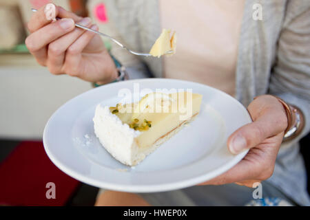 Mittleren Bereich der Frau essen Kuchen in Stadt Straßencafé Stockfoto