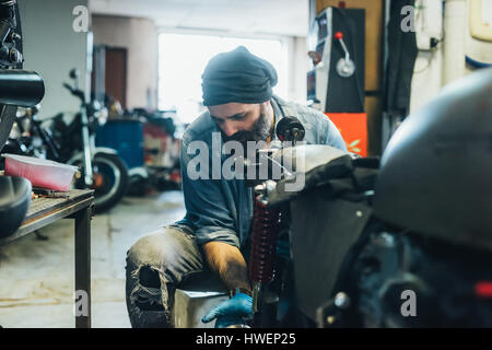 Reifer Mann, arbeiten am Motorrad in garage Stockfoto