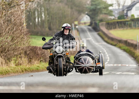 Ältere Mann und Enkel fahren Motorrad und Beiwagen auf Landstraße Stockfoto