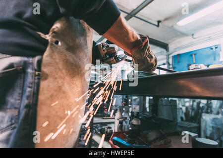 Mittleren Bereich der Metallarbeiter Schleifen Metallstab in Schmiede-Werkstatt Stockfoto