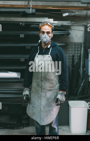 Porträt der Metallarbeiter in Staubmaske Schmiede Workshop Stockfoto