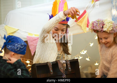 Junge und zwei Schwestern spielen dress up von Schatztruhe Stockfoto