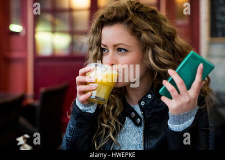 Frau im Café mit Orangensaft Stockfoto