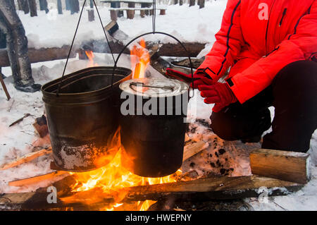 Blick auf Frau Erwärmung Hände am Lagerfeuer, Russland abgeschnitten Stockfoto