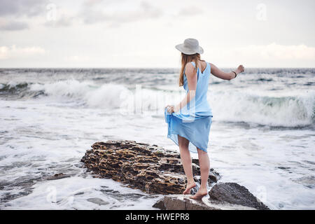 Frau Spaziergang auf Felsen im Meer Stockfoto