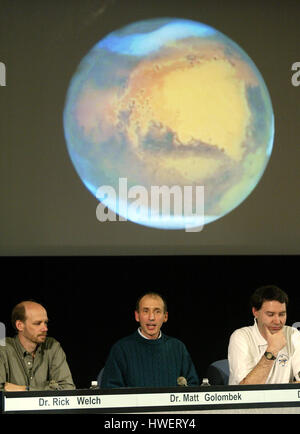 Matt Golombek,(C) ein Wissenschaft-Team-Mitglied mit dem Mars Exploration Rovers (MER) Team bespricht den Status des Rover Gelegenheit während einer Pressekonferenz am Jet Propulsion Laboratory, Mittwoch, 28. Januar 2004, in Pasadena, Kalifornien. Ein Foto vom Mars, aufgenommen vom Hubble Space Telescope wird oben angezeigt. Rick Welch, (L) und Jim Bell (R) der MER werden ebenfalls angezeigt. Foto von Francis Specker Stockfoto
