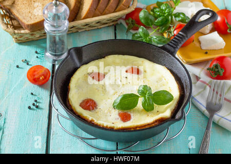 Omelette mit Tomaten und Sulguni Käse mit frischem Gemüse auf einem Holztisch. Das Konzept einer gesunden Ernährung und Entgiftung Ernährung. Stockfoto