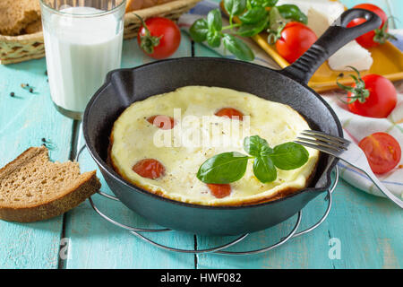 Omelette mit Tomaten und Sulguni Käse mit frischem Gemüse auf einem Holztisch. Das Konzept einer gesunden Ernährung und Entgiftung Ernährung. Stockfoto