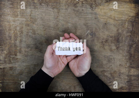 männliche Hände halten eine weiße leere danke auf Blatt Papier Stockfoto