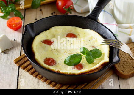 Omelette mit Tomaten und Sulguni Käse mit frischem Gemüse auf einem Holztisch. Das Konzept einer gesunden Ernährung und Entgiftung Ernährung. Stockfoto