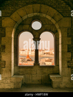 Das ungarische Parlament, das durch ein Fenster der Fischerbastei im Budapester Schloss gesehen wird Stockfoto
